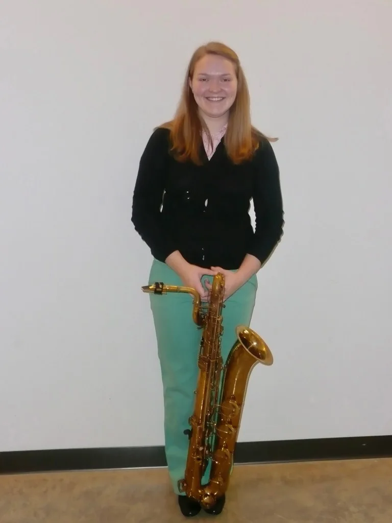 Photo of Grace in college with her baritone saxophone
