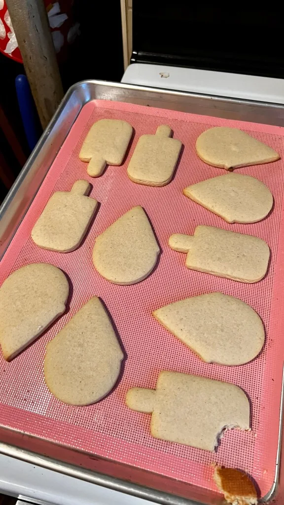 Baked sugar cookies on a perforated baking mat on a baking sheet 