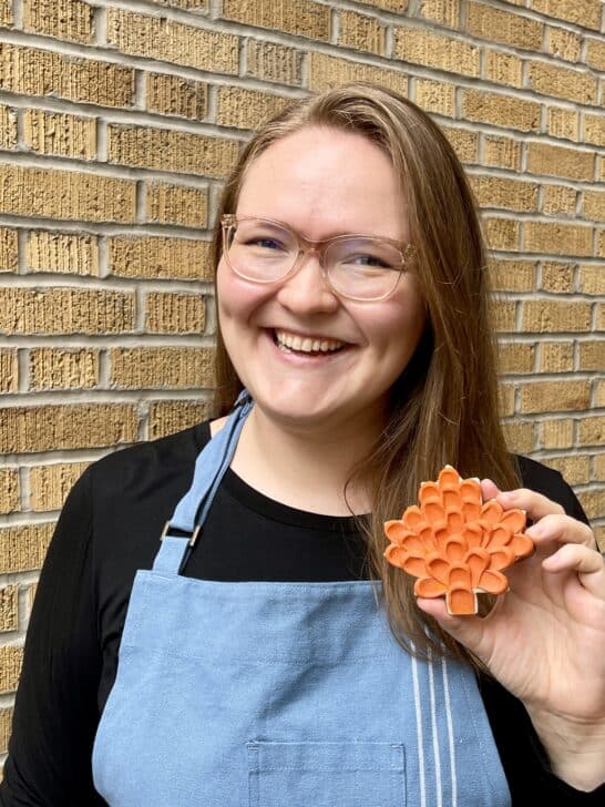 picture of grace gaylord holding an orange maple leaf cookie 