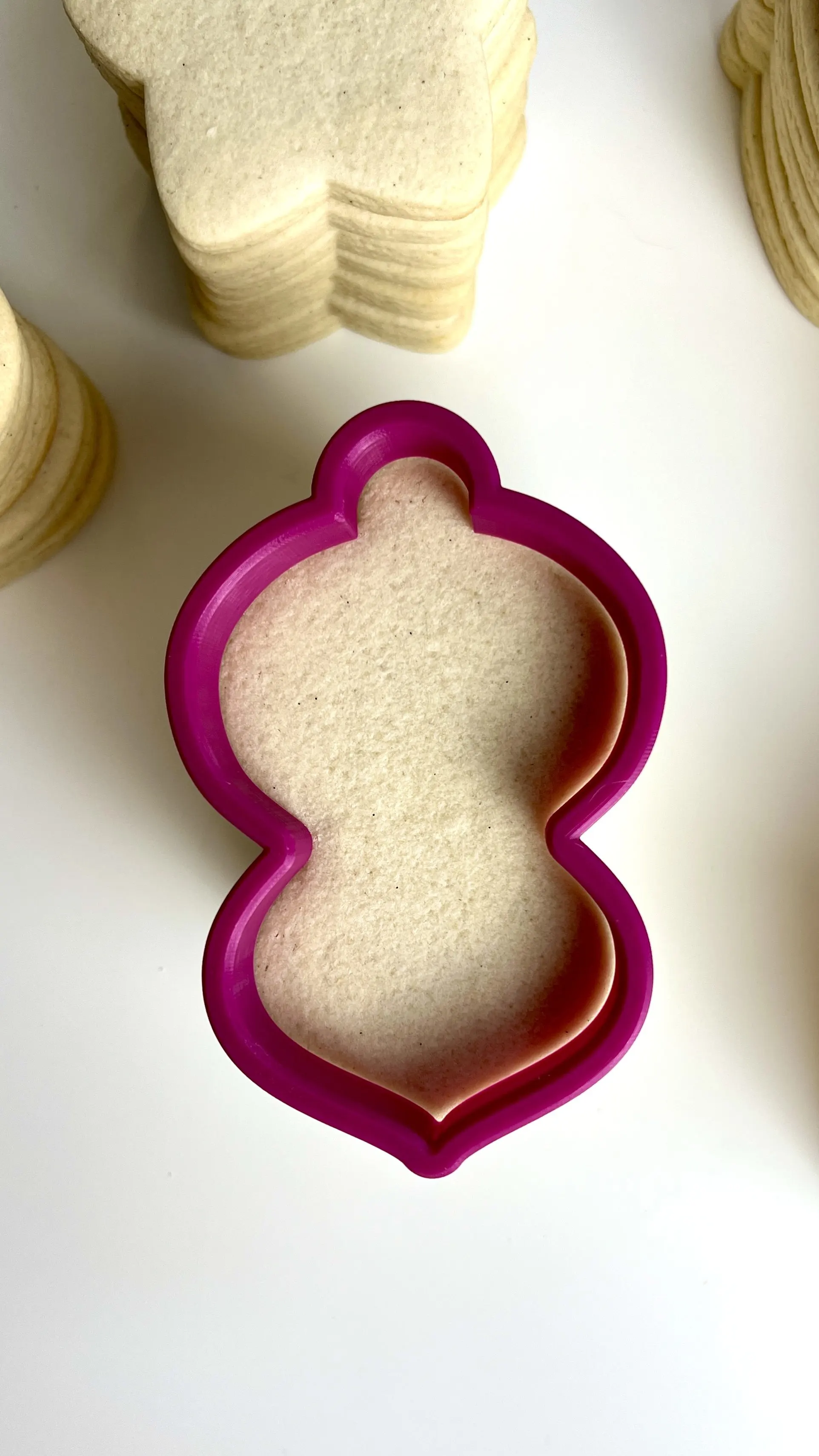 Cookie cutter on top of freshly baked sugar cookies to show no spread